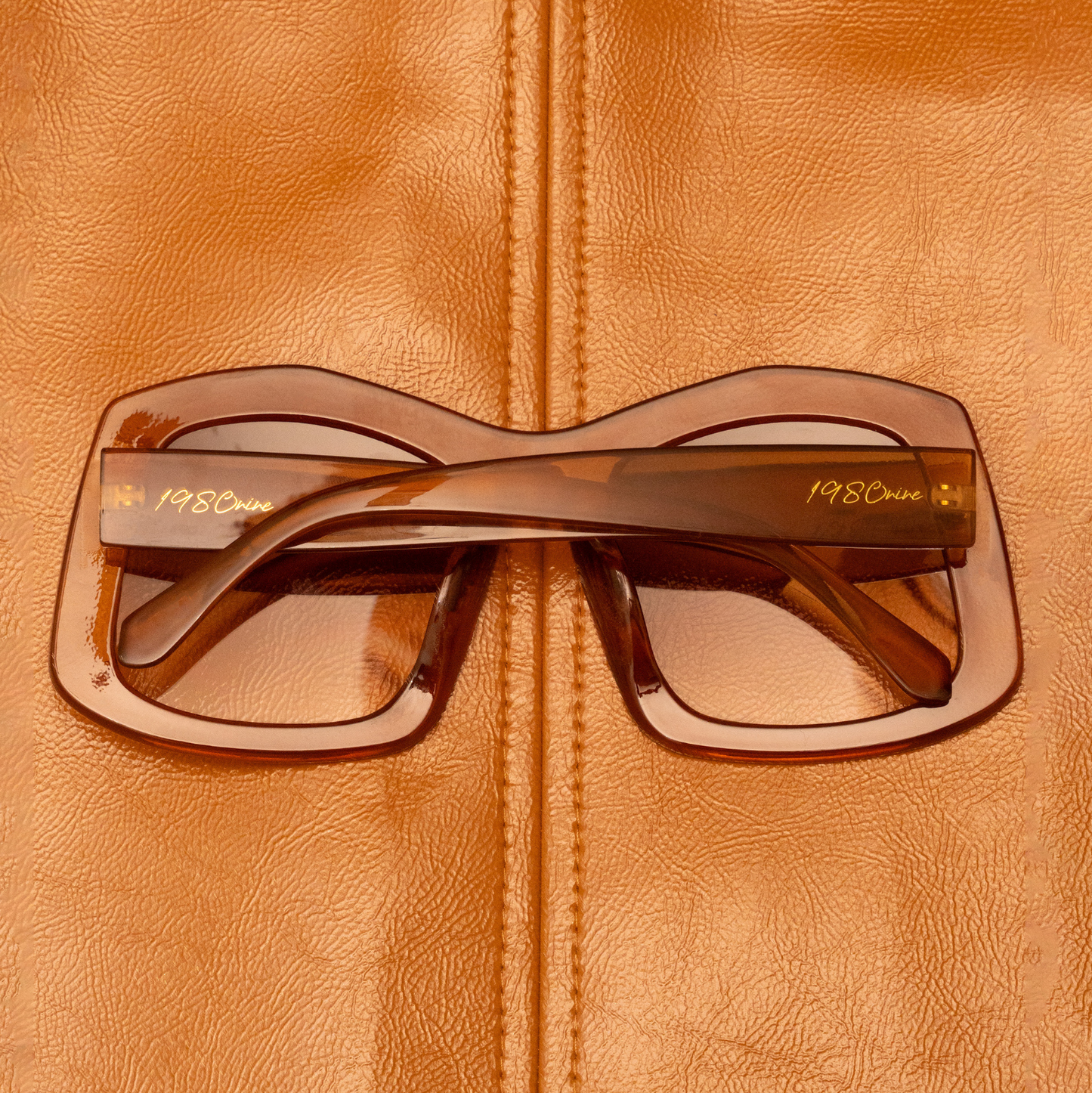 Brown sunglasses on a brown leather surface