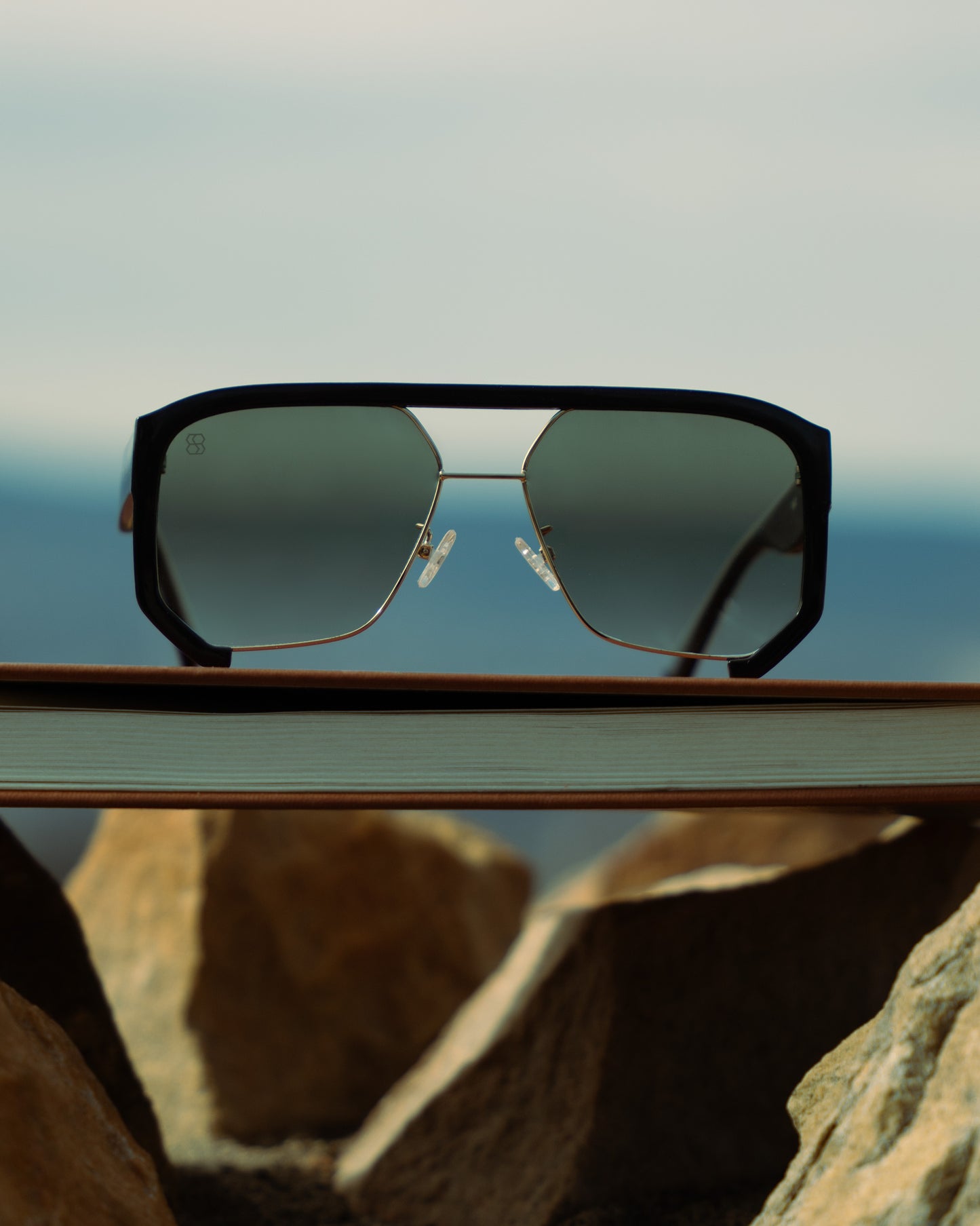 1980nine Sunglasses on a book with a mountainous landscape in the background