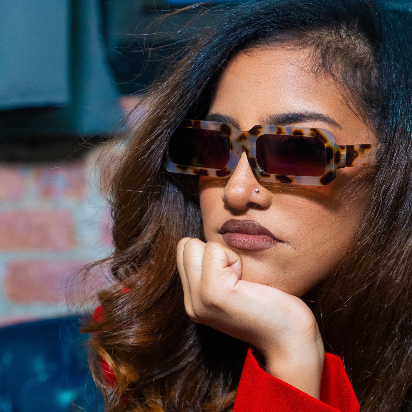 Woman wearing tortoiseshell sunglasses with a blurred background
