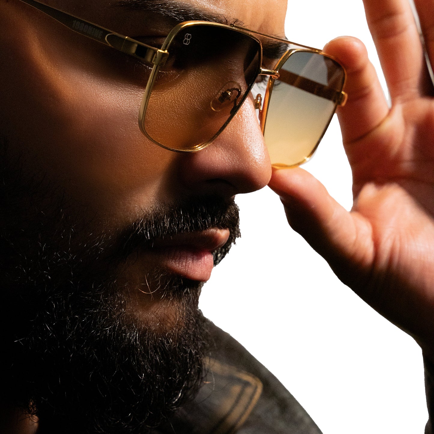 Model wearing gold metal aviator sunglasses with amber gradient lenses and sleek metal frame.