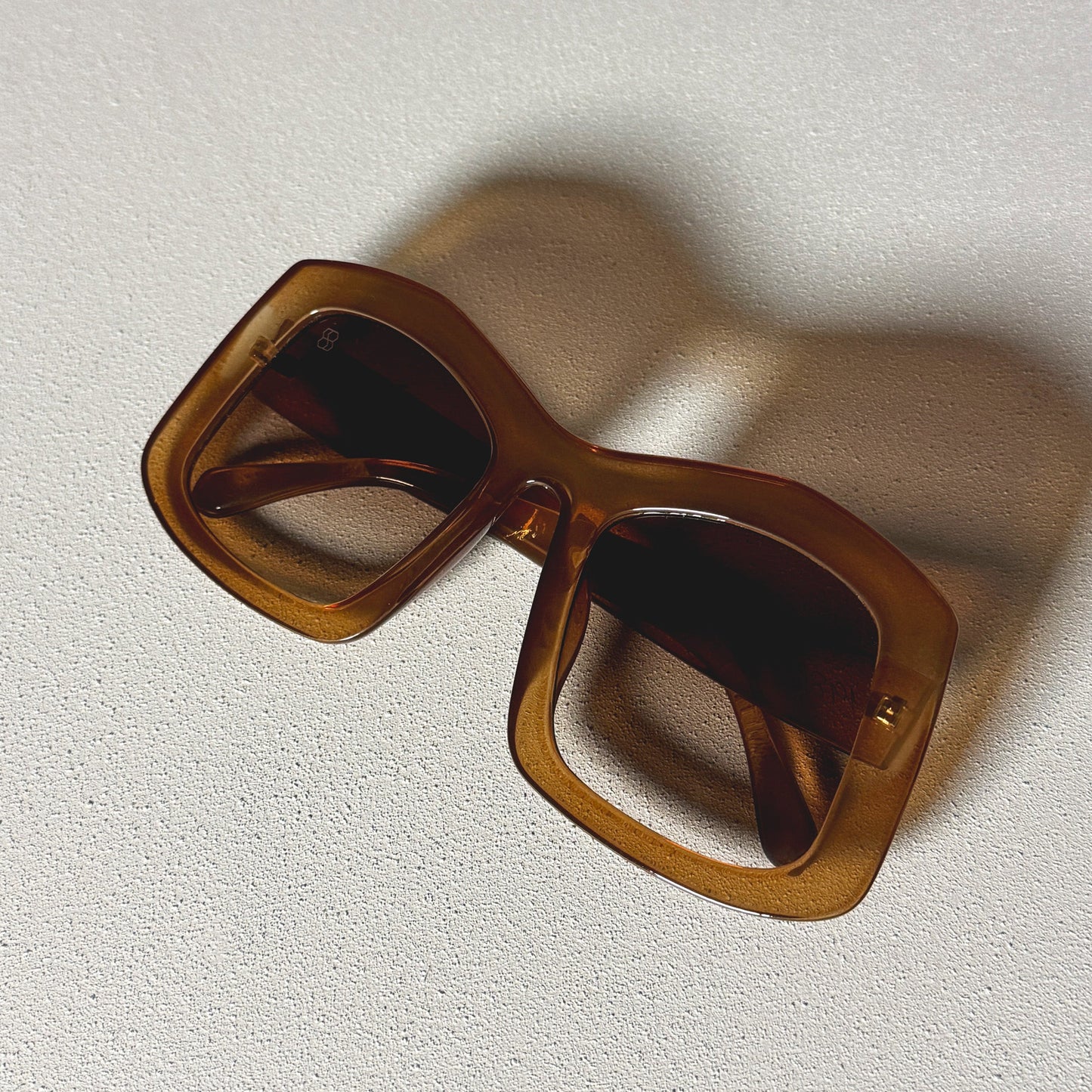 Brown 1980nine sunglasses on a textured white surface