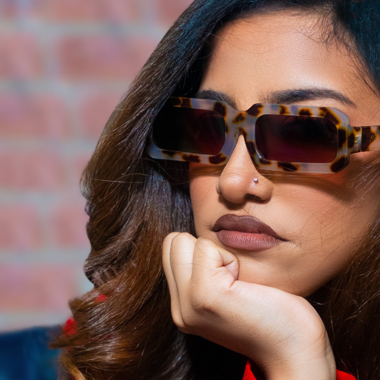 Woman wearing tortoiseshell sunglasses with a blurred background