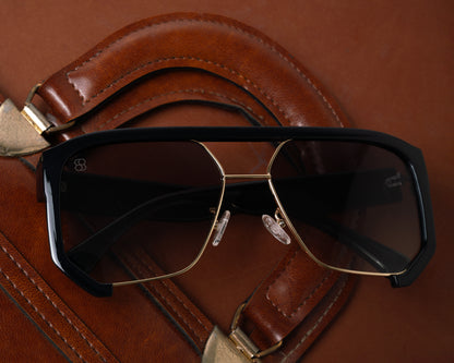 1980nine sunglasses with black and gold frame on a brown leather surface