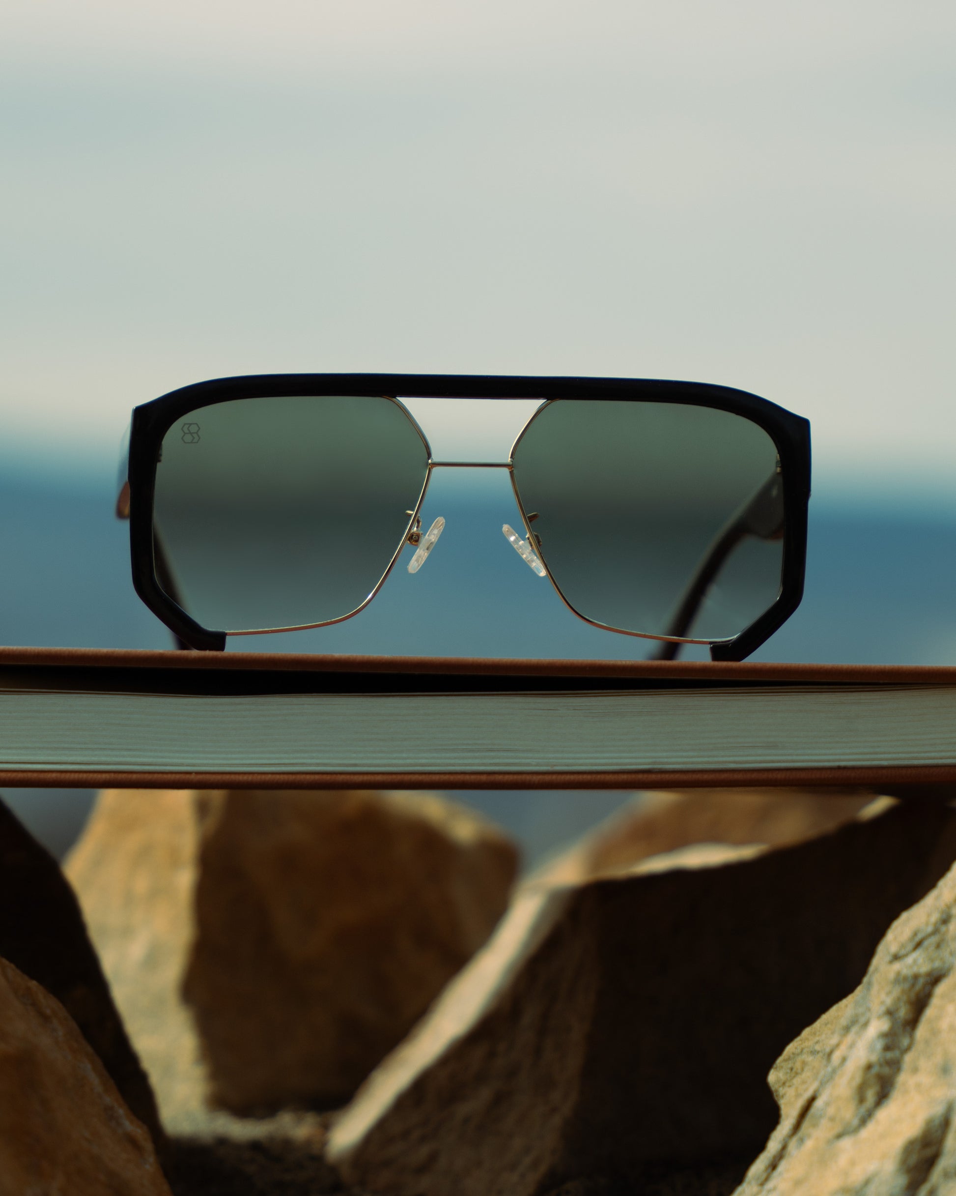 1980nine Sunglasses on a book with a mountainous landscape in the background
