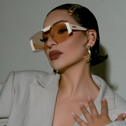 Model Marissa Roche wearing oversized frameless shield sunglasses with sculptural lenses and bold color-accented temples
