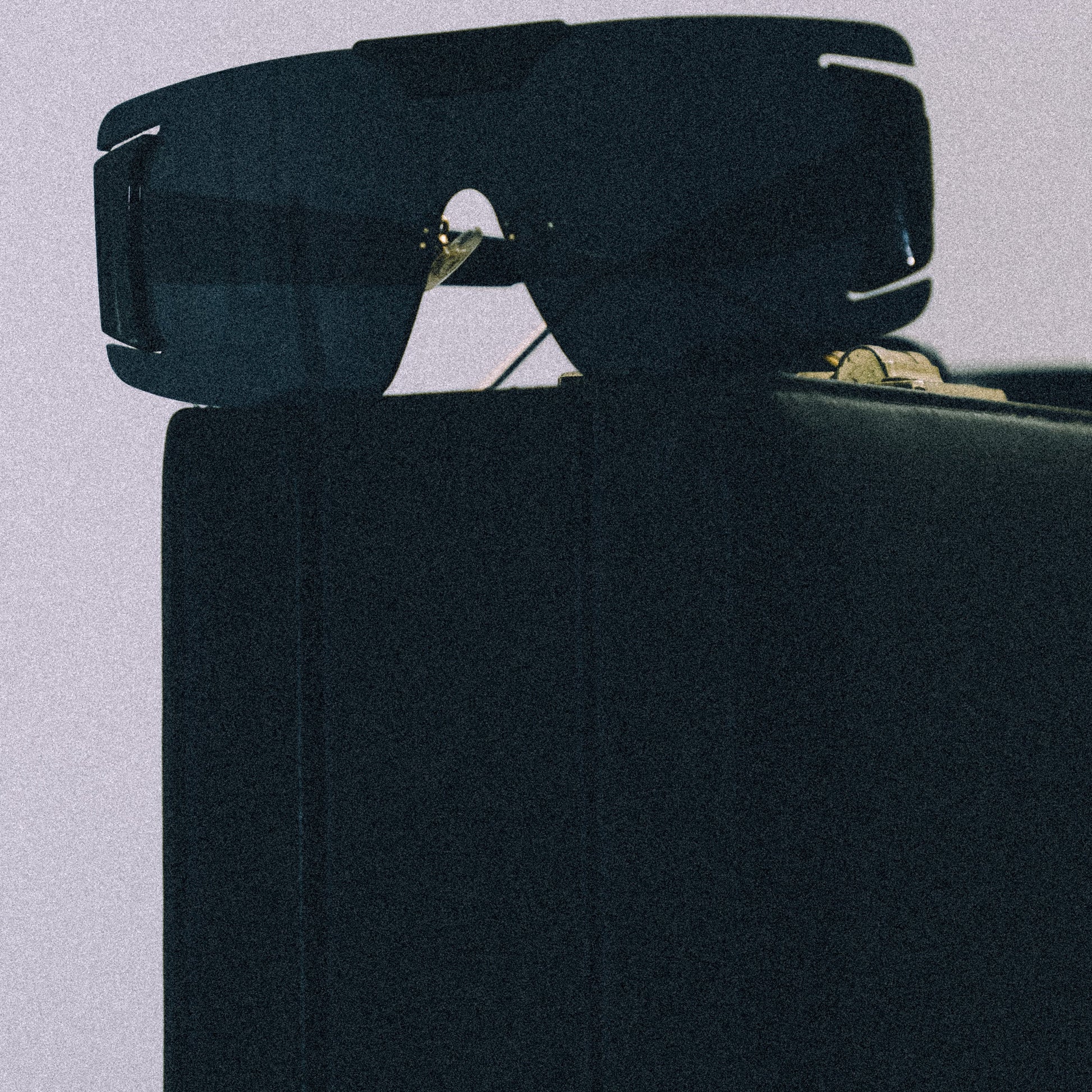 Black sunglasses with gold accents on a light gray background
