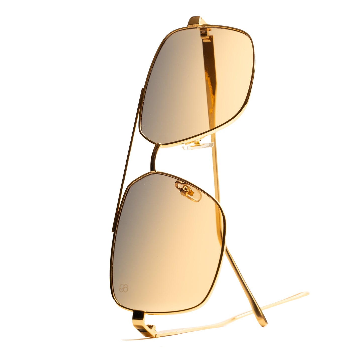 Side view of metal aviator sunglasses with thin gold arms and amber gradient lenses. 