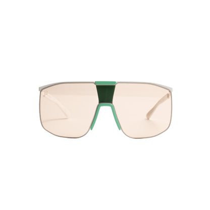 oversized shield sunglasses with emerald green bridge and blush tinted single shield lens.