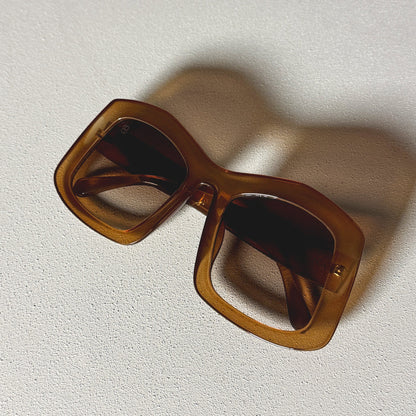 Brown 1980nine sunglasses on a textured white surface