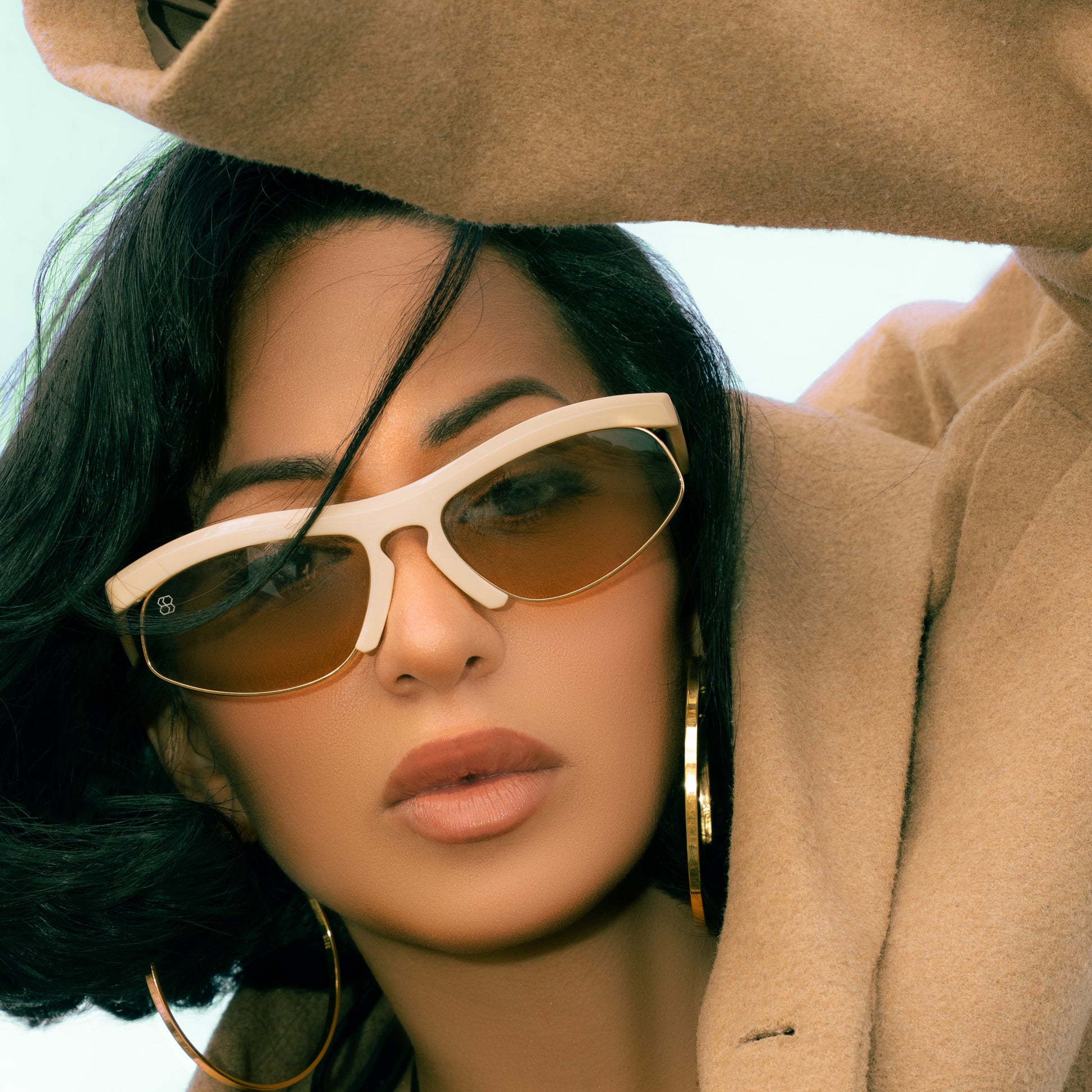 Woman wearing sunglasses FAYE semi-rimless and a beige coat with a blurred background