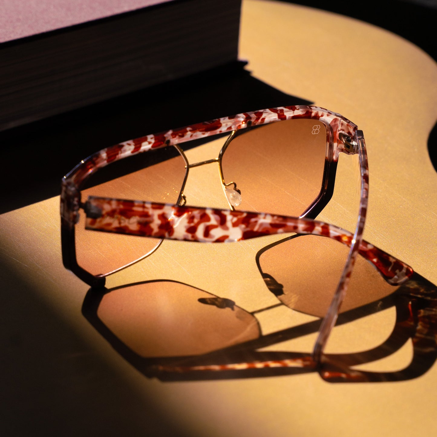 1980nine Sunglasses with a tortoiseshell frame on a dark surface